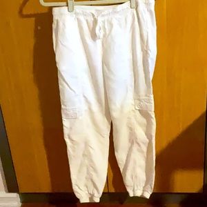 White pants with six pocket crop style elastic cuff to the bottom